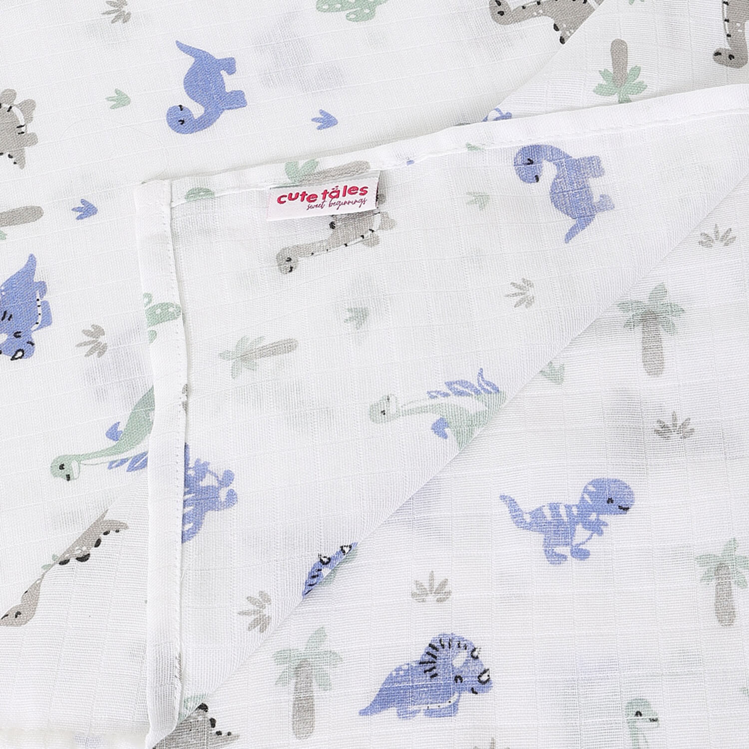 cutetales muslin fabric with dinosaur pattern and 'cute tales' label on a white background