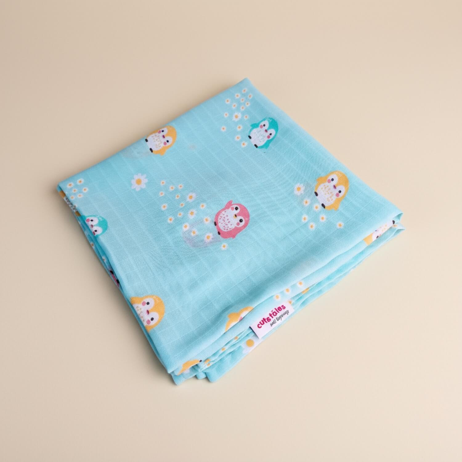 Cutetales Folded blue fabric with cartoon characters and flowers on a beige background